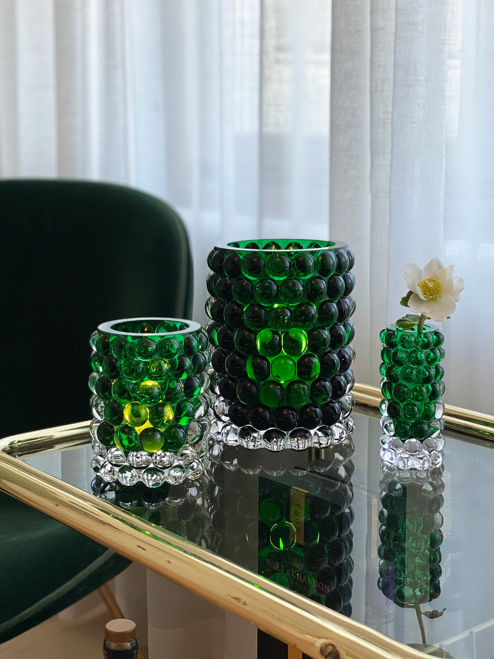 Hurricane-Boule-Green-Lifestyle-5.jpg Hurricane Boule Lamps in green glass on glass table | Front of Sweden